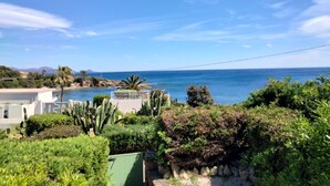 Vista sulla costa con cielo sereno, piscina e vegetazione lussureggiante.