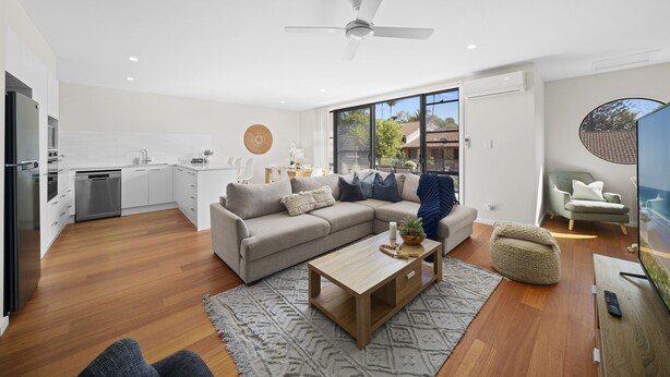 A modern living room with a sofa, coffee table, and a television. - Spacious 4BR w/ Water Views (Port Macquarie)