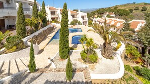 A resort with a swimming pool, white buildings, and a hilly landscape. - WELCS CASA ADOSADA 215 EMP con piscina comunitaria (Rosas / Roses)