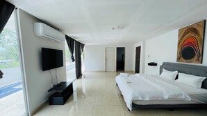 A modern hotel room with a large bed, a flat-screen TV, and a painting on the wall.