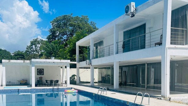 A modern two-story building with a swimming pool.