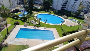 Une grande piscine entourée de verdure et de bâtiments.