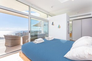 A modern hotel room with a large bed, a view of the sea, and a balcony with wicker furniture. - Vista Mar | Sea View - Pool - Terrace (Fuengirola)