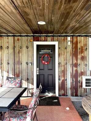 A rustic exterior with a wooden door, a bench, and a table. - The Rustic Suite on Bourbon Trail (Loretto)