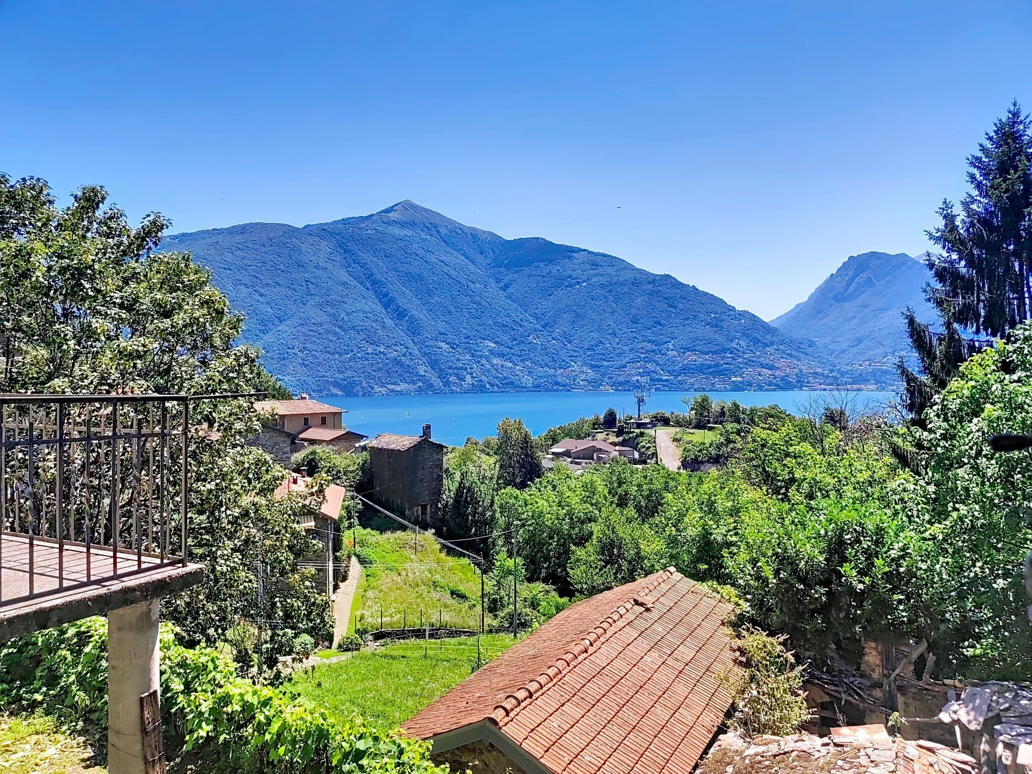 A mountainous landscape with a lake, houses, and a clear sky.