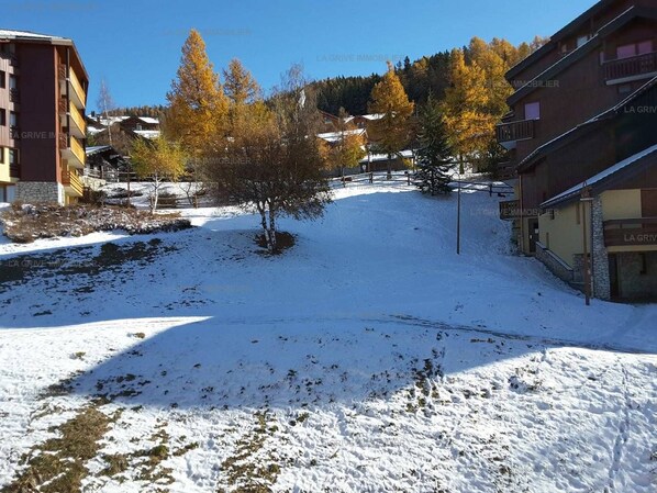 A snow-covered outdoor area with buildings and trees.
