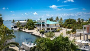A waterfront property with a marina, multiple buildings, and lush greenery. - Wahoo Waterway: Charming 3BR Canal Front Home in Cudjoe Key with Dockage & Pet-Friendly Amenities! (Cudjoe Key)