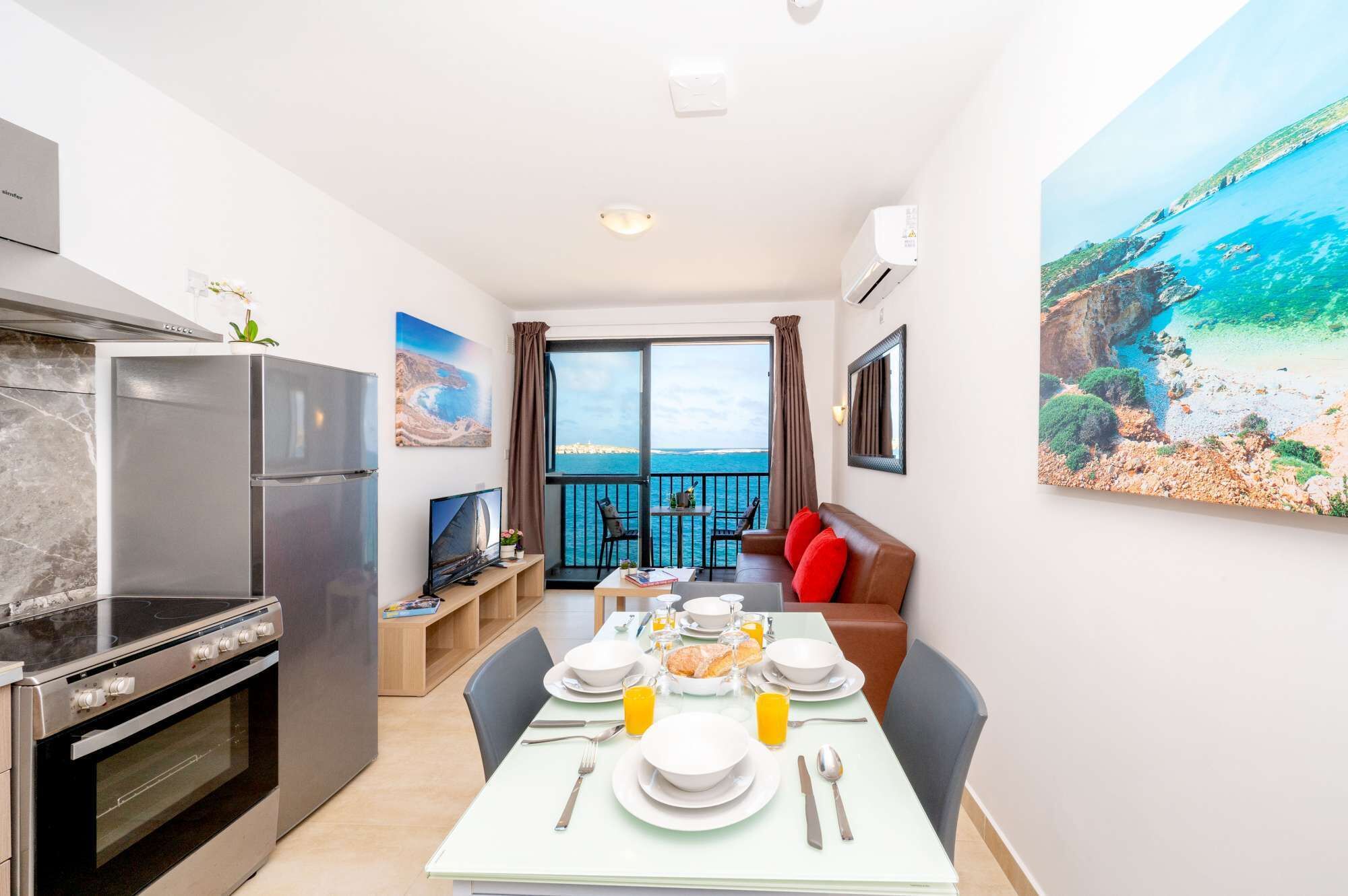 A modern kitchen with a built-in oven and a dining area with a table set for breakfast.