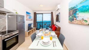 A modern kitchen with a built-in oven and a dining area with a table set for breakfast.