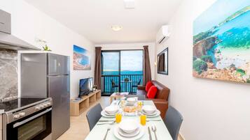A modern kitchen with a built-in oven and a dining area with a table set for breakfast.