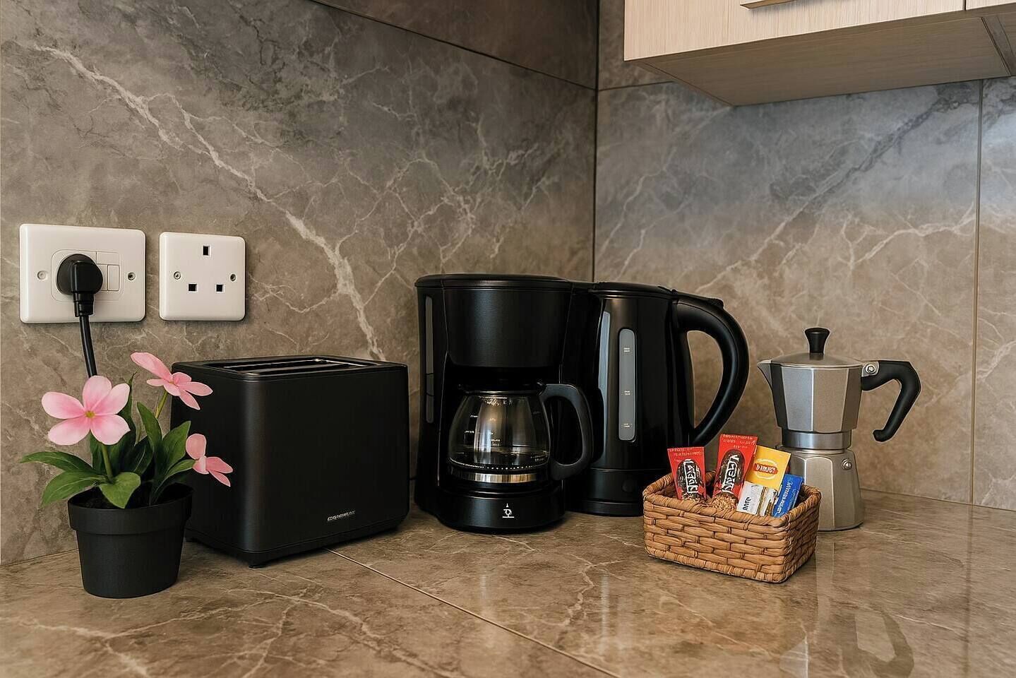 Ett kök med en brödrost, en kaffebryggare och en korg med kaffekapslar.
