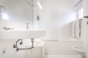 A modern bathroom with a white sink, mirror, and bathtub. - Cosy flat, ideal for 4px (Tavira)