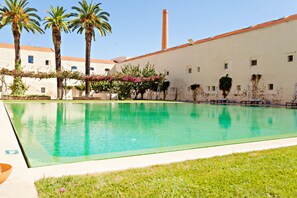 A swimming pool with palm trees and a building in the background. - Cosy flat, ideal for 4px (Tavira)