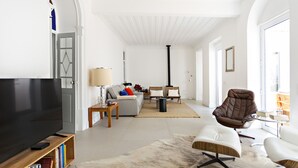 A modern living room with a flat-screen TV, a sofa, a brown leather chair, and a coffee table. - Modern, w/ pool and terrace (Vila Real de Santo António)