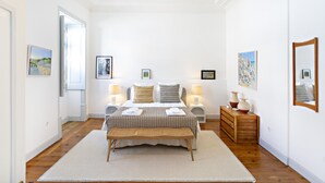 A bedroom with a bed, bedside lamps, a wooden bench, and a dresser. - Modern, w/ pool and terrace (Vila Real de Santo António)