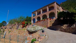 A stone building with multiple balconies and a paved driveway. - Appartement 2 en Pierre (Ota)