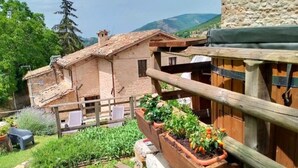 Un edificio rústico con pared de piedra y balcón de madera.
