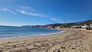 A beach with clear blue water, sandy shore, and a hilly landscape in the background. - Spectacular mountain views in a romantic location. Close to Mojacar beaches. (Turre)
