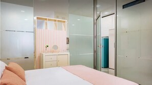 Ein modernes Schlafzimmer mit einem Bett, einem Schminktisch mit Spiegel und einem Kleiderschrank.