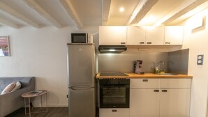 Una cocina compacta equipada con refrigerador, horno, microondas y cubierta de madera.