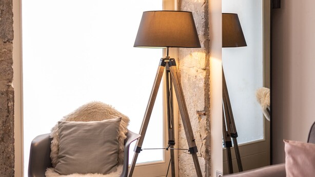 Una sala moderna con un sillón mecedor, una lámpara de pie y un sofá.