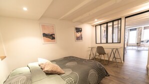 Un dormitorio con cama, escritorio y silla.