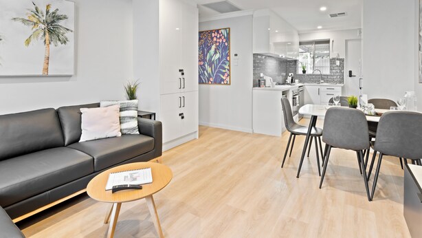 A modern apartment with a living room, dining area, and kitchen.