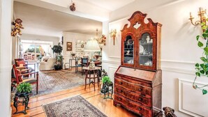 A spacious living room with a wooden cabinet, a chandelier, and a large window. - Villa Elide with private pool (Massa Lubrense)