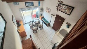 Un comedor con una mesa y sillas, un banco, una puerta y vistas al exterior a través de un ventanal.