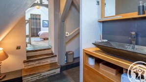 Un baño moderno con tocador de madera, un espejo grande y un lavamanos.