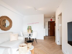 Relax in this stylish living space with a sofa, dining table, and wicker baskets.