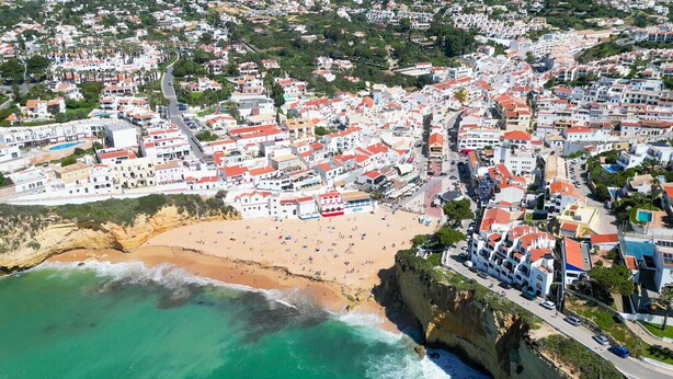 An aerial view of a coastal town with a beach, buildings, and a road. - Queen of the Bay: Amazing Sea view in the heart of Carvoeiro (Carvoeiro)