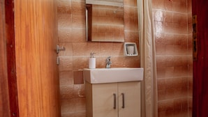 Un baño con lavamanos, espejo y cortina de ducha.