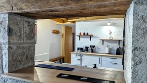Une cuisine moderne avec un plan de travail en bois, des armoires blanches et un porte-casseroles suspendu.