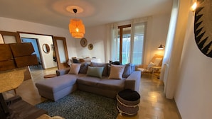 Un soggiorno moderno con un divano componibile, un poggiapiedi decorato e un tappeto ornamentale.