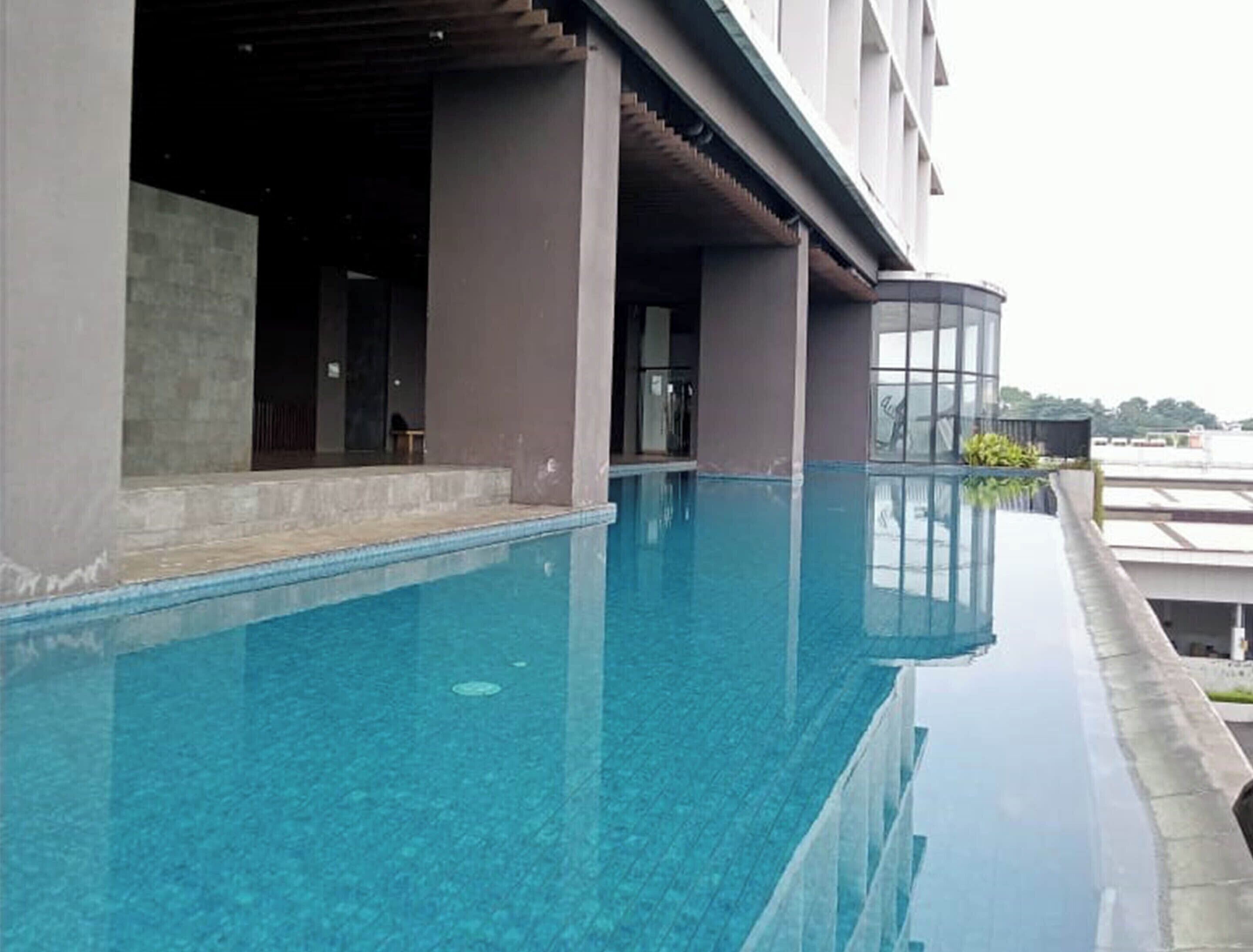 Un edificio moderno con piscina infinita en la azotea.