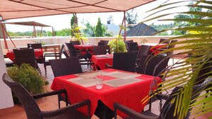 An outdoor patio with tables and chairs, covered by a canopy. - Lux Suites Diani Airstrip Villas  (Diani Beach)