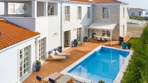 A white building with a swimming pool, outdoor seating, and potted plants. - Villa Fiordaliso by Villas Guide (Tar)