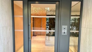 Una entrada moderna con puerta de cristal y cerradura con teclado.