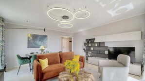 Una sala moderna con un sofá marrón, una mesa de centro y un televisor.