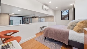 A modern bedroom with a bed, a desk, and a window overlooking a balcony. - NEW Luxe DT Austin Oasis | Pool | Casita (Austin)