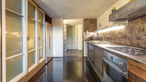 A modern kitchen with a stainless steel stove, a built-in oven, and a marble countertop. - Iconic apartment with unique Colosseum view (Roma)