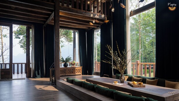A spacious room with a long wooden bench, a wooden table, and a view of a balcony with a railing. - P'apiu Resort (Ngoc Duong)