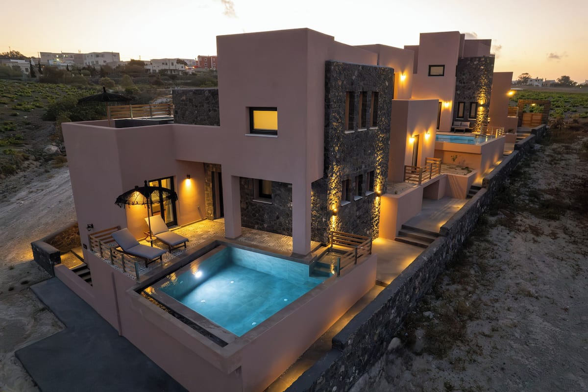 Uma villa moderna com piscina, área de estar ao ar livre e fachada de pedra.