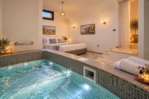 Een moderne hotelkamer met een wellnessruimte, inclusief een jacuzzi en een bed.