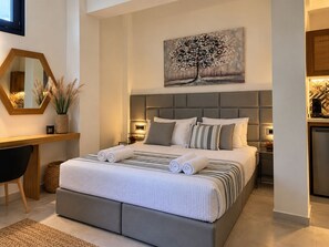 Un dormitorio moderno con una cama grande, mesitas de noche, un escritorio y un cuadro en la pared.