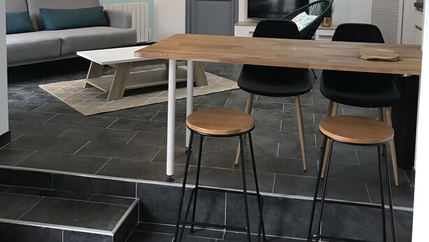 A modern living space with a dining area, a sofa, a TV, and a staircase. - Maisont3 Duplex Avec Cour Privée à 400 Plage (Angoulins)