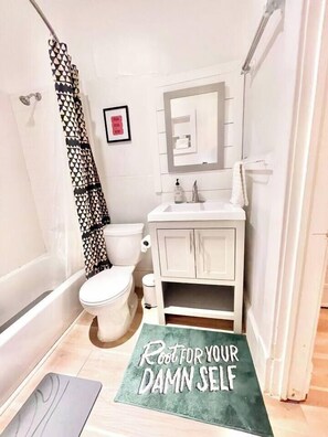 A bathroom with a toilet, sink, and shower curtain. - WALK to Beltline, Piedmont, Ponce City Market, VaHi, Midtown! LOCATION! (Atlanta)