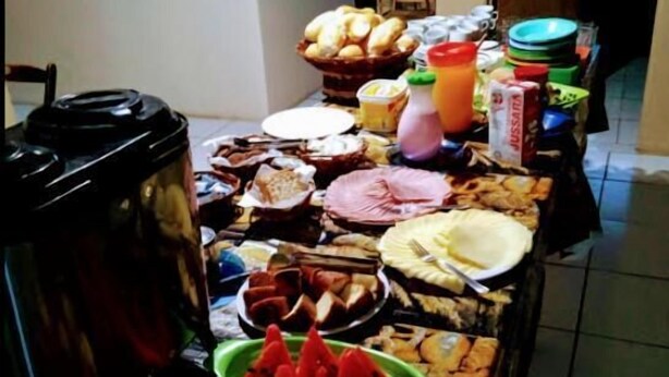 Una mesa de buffet con diversos alimentos, como frutas, pan y salsas.