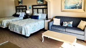 A hotel room with two beds, a sofa, a coffee table, and artwork on the walls. - Delightful Oceanview Studio (Myrtle Beach)
